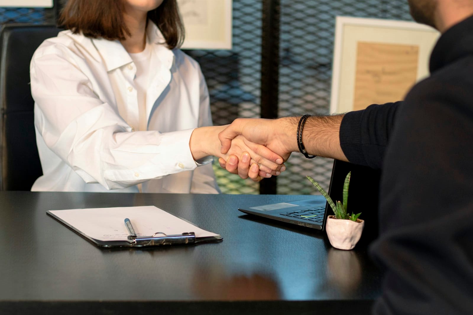 Two professionals shaking hands to close a business deal